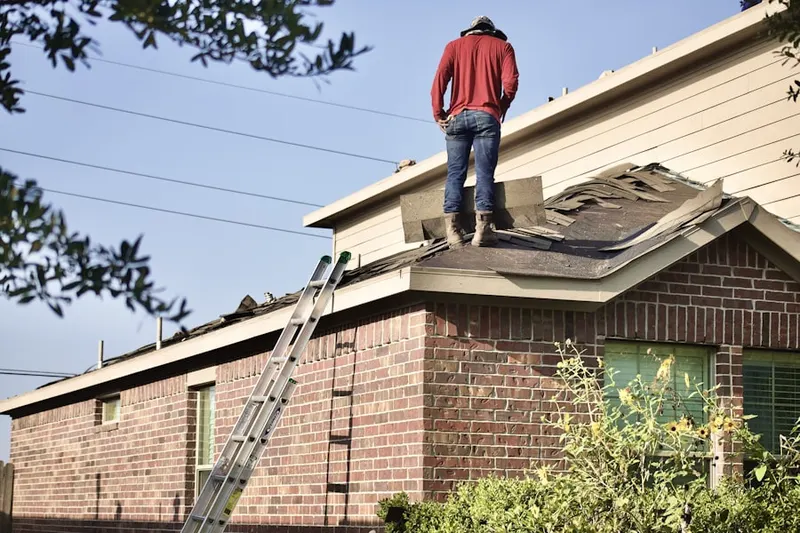Professional roofer working on a residential roof in Huron